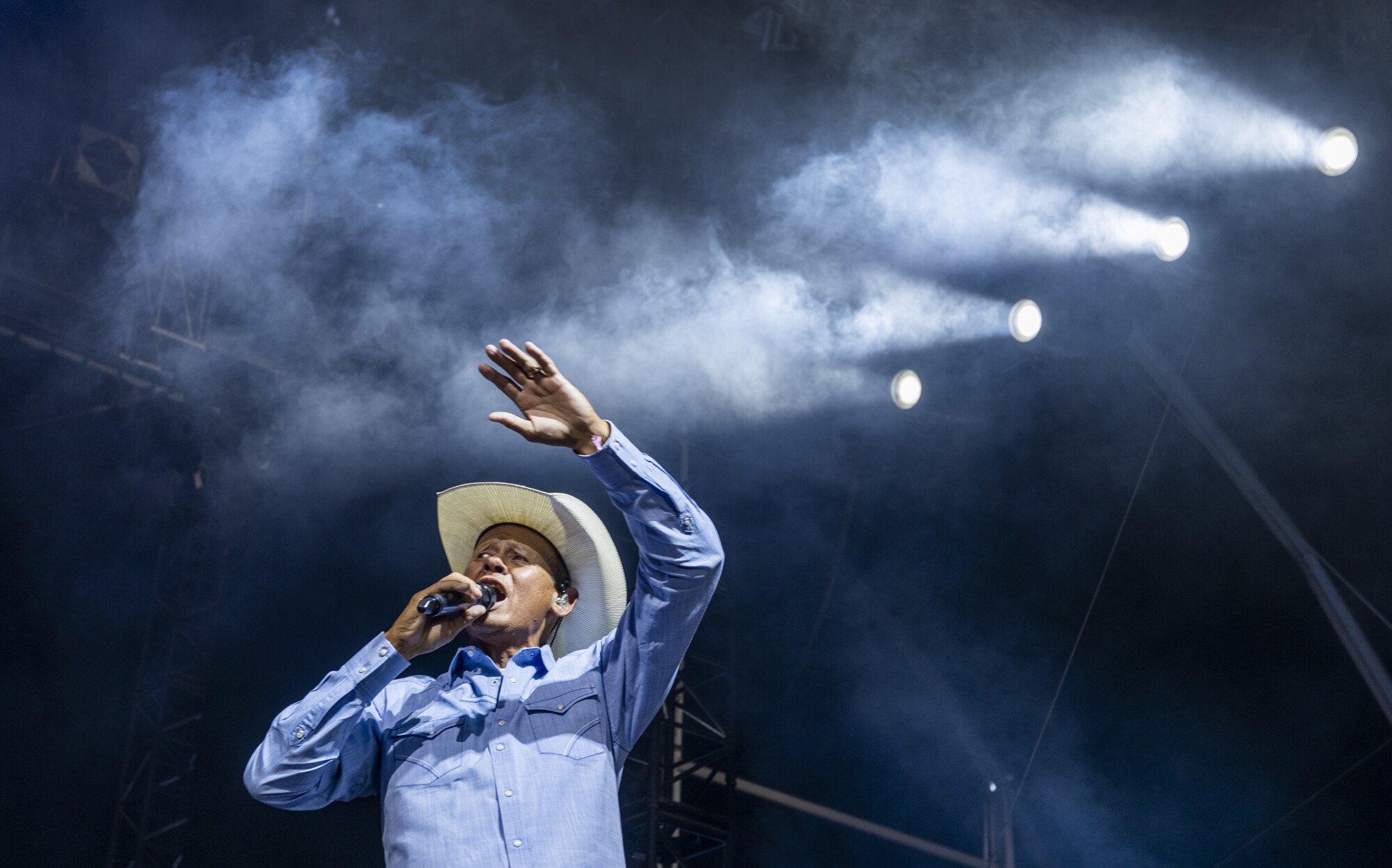Neal McCoy lifts his arm and sings onstage