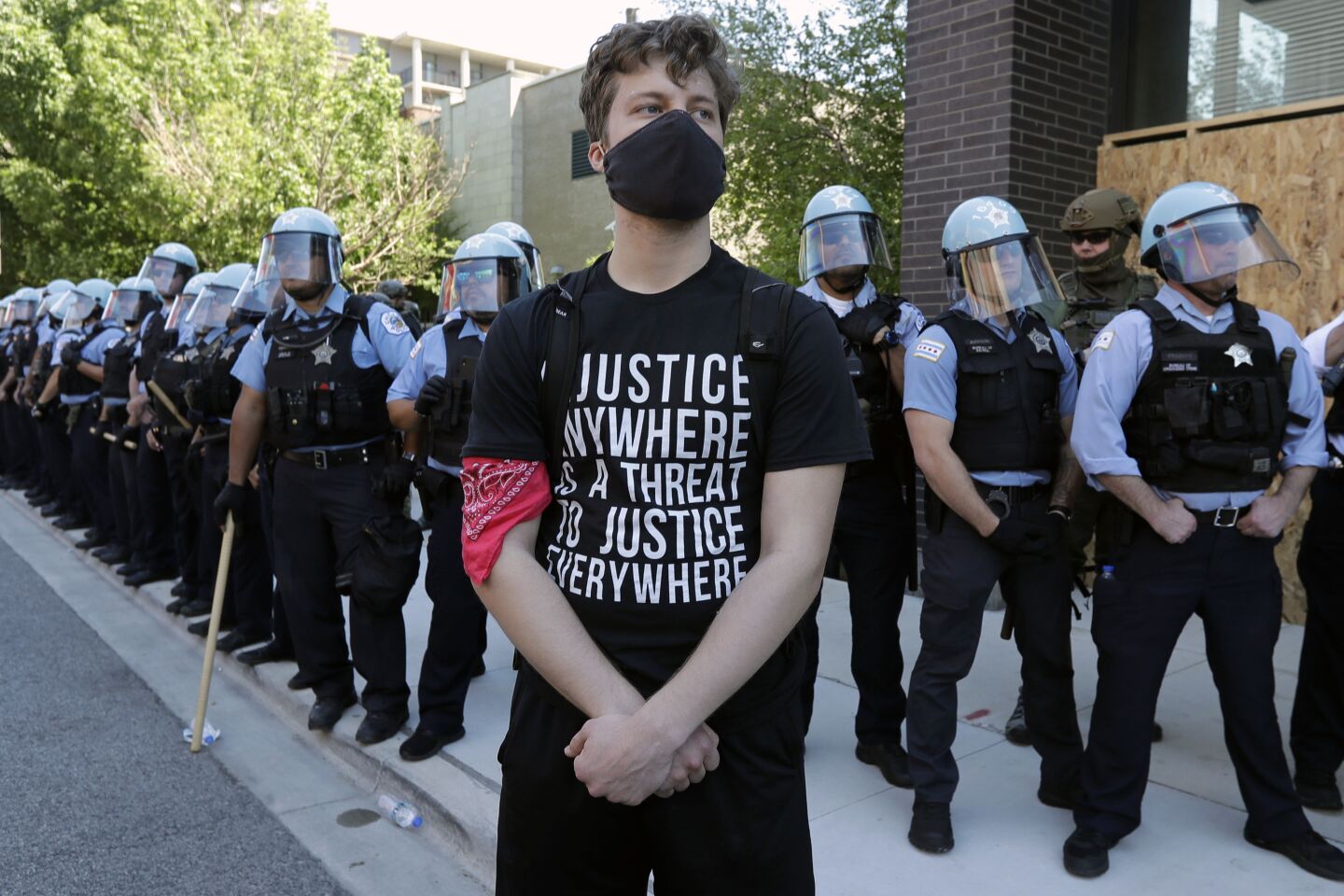 A demonstrator stands in front of Chicago Police officers during the March for Justice in honor of George Floyd Saturday, June 6, 2020, in Chicago. Demonstrators who gathered at Union Park marched through the city's West Side on Saturday afternoon, as the city prepared for another weekend of rallies. (AP Photo/Nam Y. Huh)