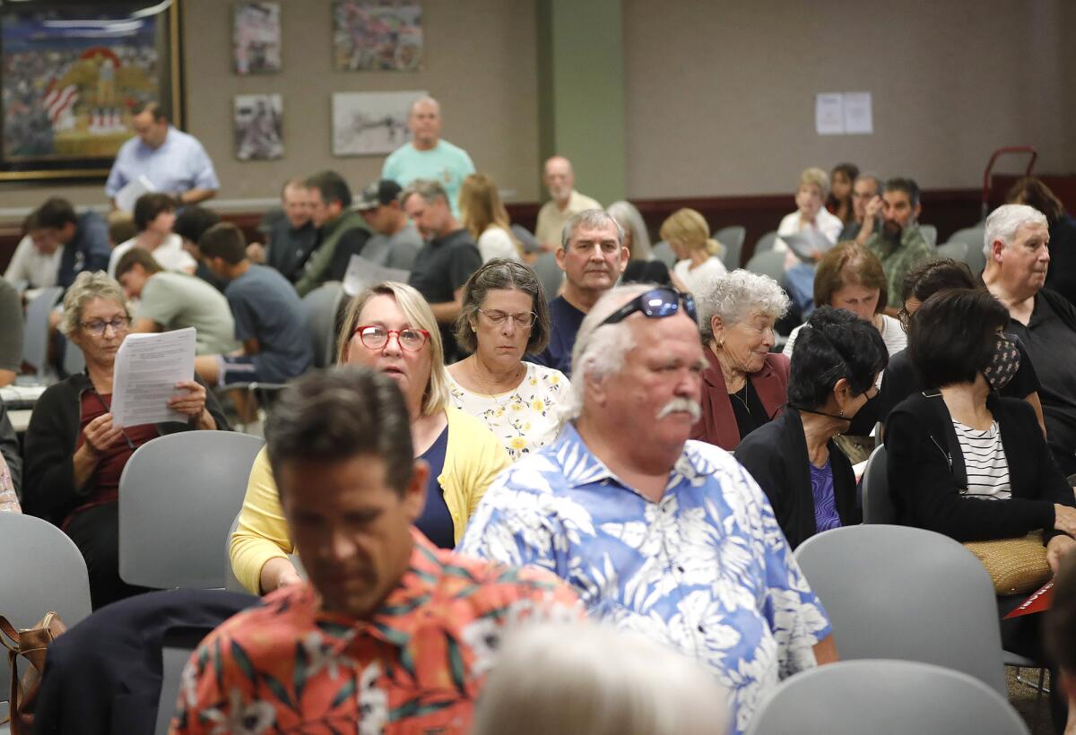 People watch Tuesday's Huntington Beach City Council meeting from an overflow room.
