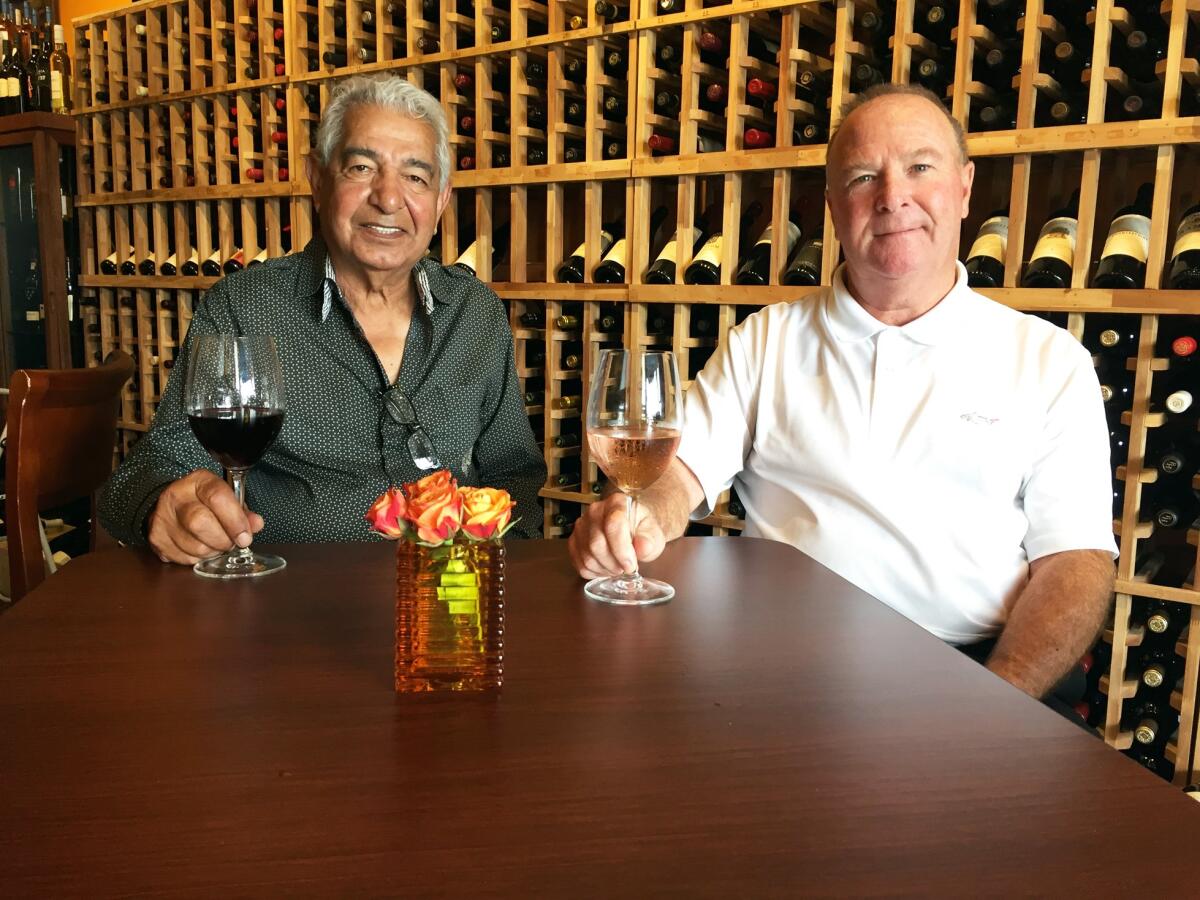 Owners Mayur Pavagadhi and Steve Barr share a glass of wine in the newly opened Paon Wine Bar & Bistro in Carlsbad. The restaurant opened July 1 in the former Paon tasting room and bottle shop.