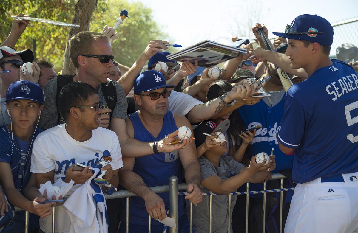 Fans crowd a barricade to get autographs from Dodgers shortstop Corey Seager after a spring training session at Camelback Ranch on Feb. 27 in Glendale, Arizona.