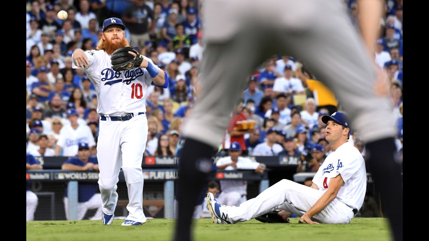 Dodger starter Rich Hill watches as Justin Turner throws to first base after fielding Justin Verlander's sacrifice bunt in the third inning.