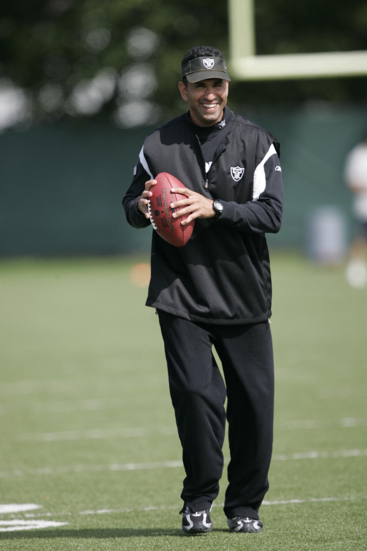 L'entraîneur des receveurs des Raiders d'Oakland, Sanjay Lal, tient un ballon de football lors du camp d'entraînement à Alameda en 2009.