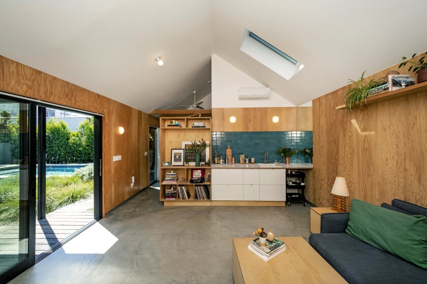 The interior of the ADU, featuring plywood walls and views of the garden and saltwater pool.