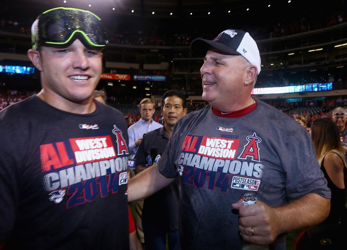 Mike Trout and Mike Scioscia celebrate after the Angels clinched the American League West with a 5-0 victory over Seattle on September 17.