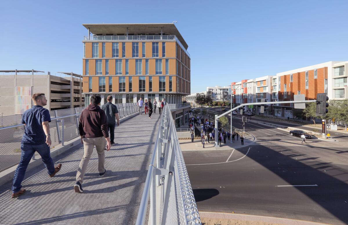 People walk on the new pedestrian bridge over Barham Drive linking the school's new Extended Learning Building (above) to the main campus. The Cal State San Marcos Innovation Hub launched at the new Extended Learning building.