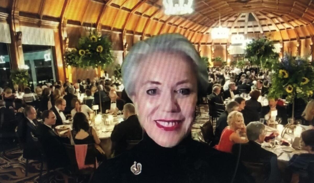 With a photo of a past Charity Ball behind her, Ellen Moxham emceed the online 2021 gala reception on Feb. 26.