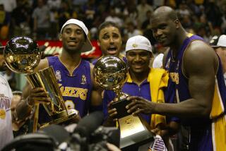 Los Angeles Lakers Kobe Bryant, left, holding the championship trophy, celebrates with teammates Rick Fox.