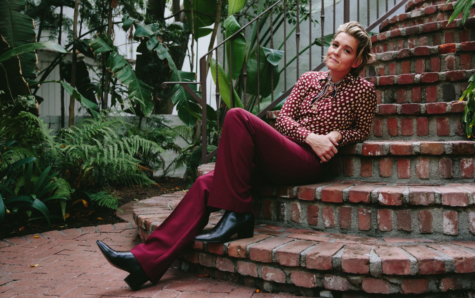 A woman seated on an outdoor brick staircase