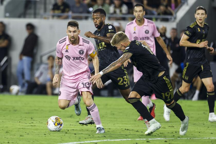 Inter Miami's Lionel Messi dibbles the the ball under pressure from LAFC's Kellyn Acosta  and Mateusz Bogusz