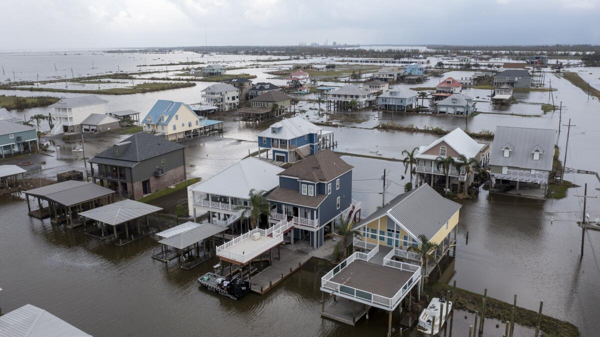 Flood waters still surround homes as residents try to recover from the effects of Hurricane Ida Wednesday, Sept. 1, 2021, in Myrtle Grove, La. (AP Photo/Steve Helber)