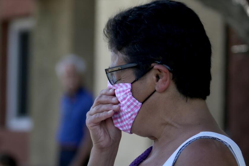 RESEDA, CA - APRIL 10, 2021:. Neighbor Lupe Cuevas is overcome with emotion as police conduct an investigation at an apartment building in Reseda where three children were reportedly stabbed to death by their mother on Saturday, April 10, 2021. The mother fled the scene but was later apprehended in the San Joaquin Valley. (Luis Sinco / Los Angeles Times)