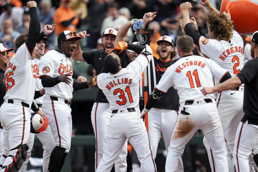 Cedric Mullins, de los Orioles de Baltimore, bebe del "Homer Hydration Station" mientras celebra con sus compañeros de equipo después de batear un jonrón de dos carreras y dejar tendidos a los Mellizos de Minnesota en la novena entrada del juego de béisbol, el miércoles 17 de abril de 2024, en Baltimore. Los Orioles ganaron 4-2. (AP Foto/Jess Rapfogel)