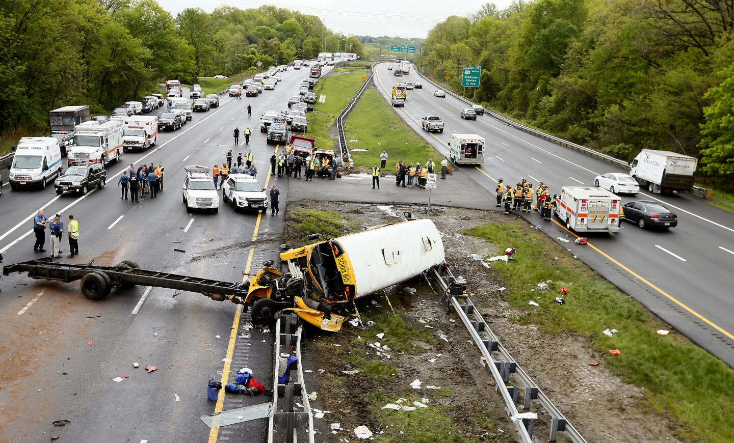 Emergency personnel examine a school bus after it collided with a dump truck, injuring multiple people, on Interstate 80 in Mount Olive, N.J., Thursday, May 17, 2018.