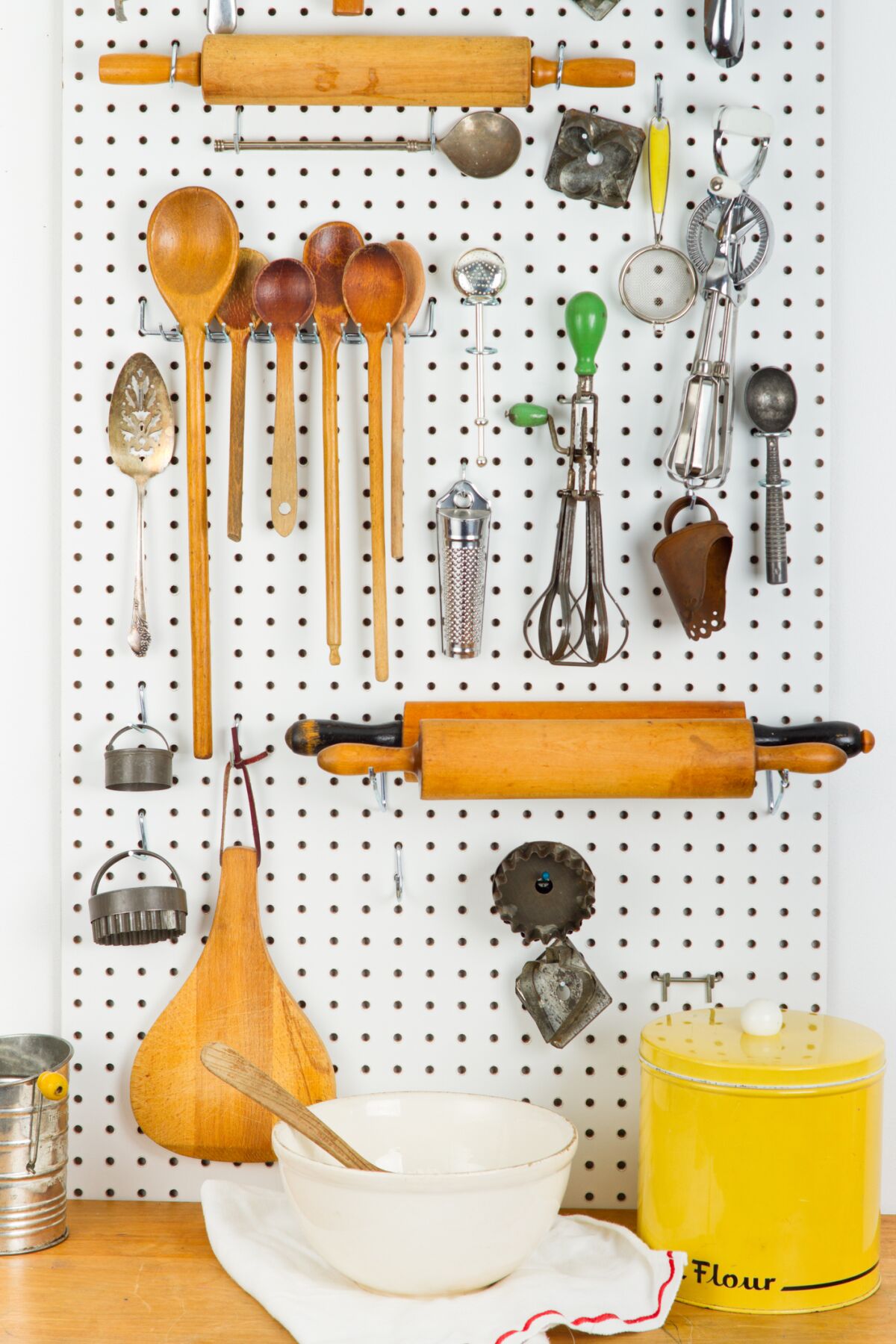 A peg board in the kitchen is a good way to display vintage baking utensils.