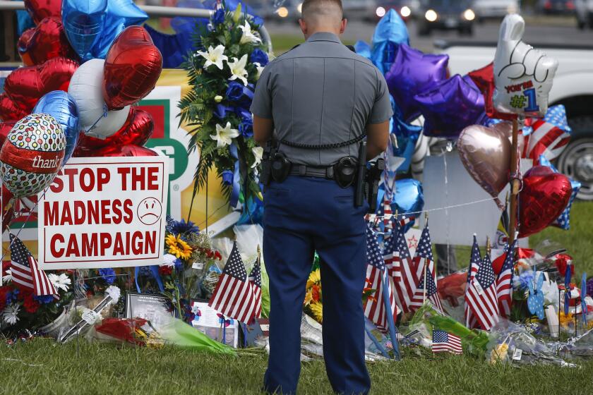 Louisiana police officer PJ Freeman stops to pay his respects at a roadside memorial for the three officers slain in Baton Rouge.