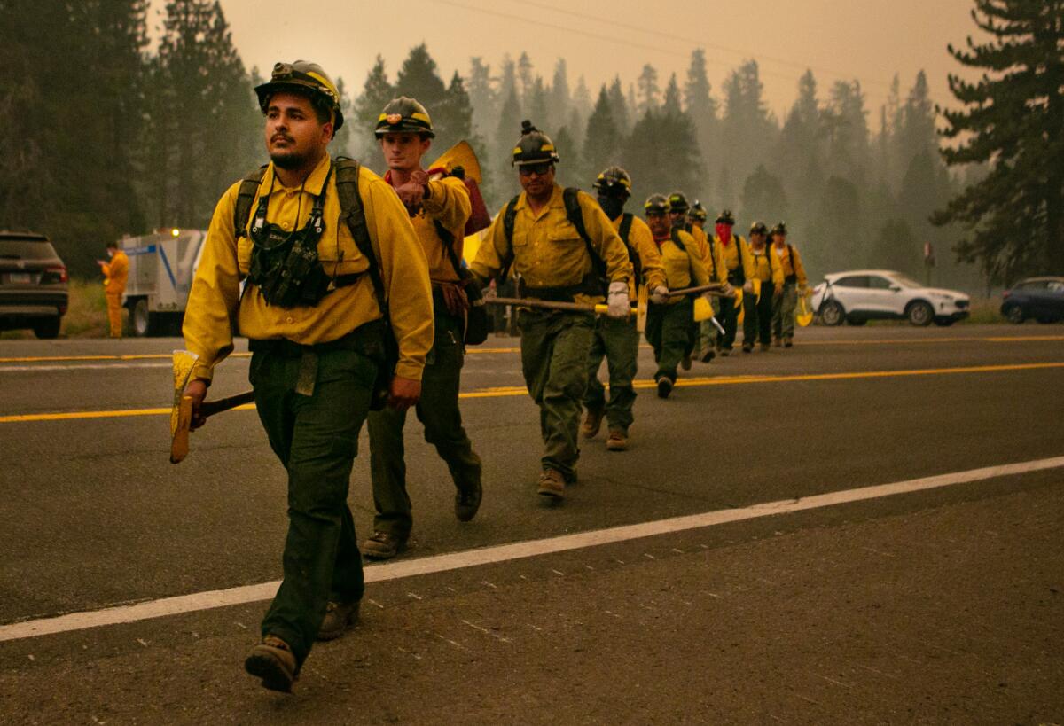 Firefighters walk in formation across Highway 50.