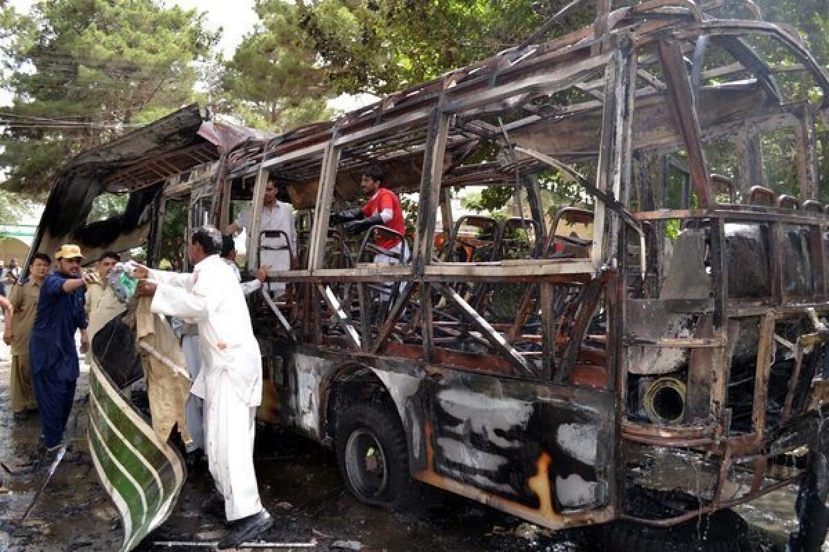 Pakistani security officials inspect a university bus after a bomb explosion in Quetta, Pakistan.