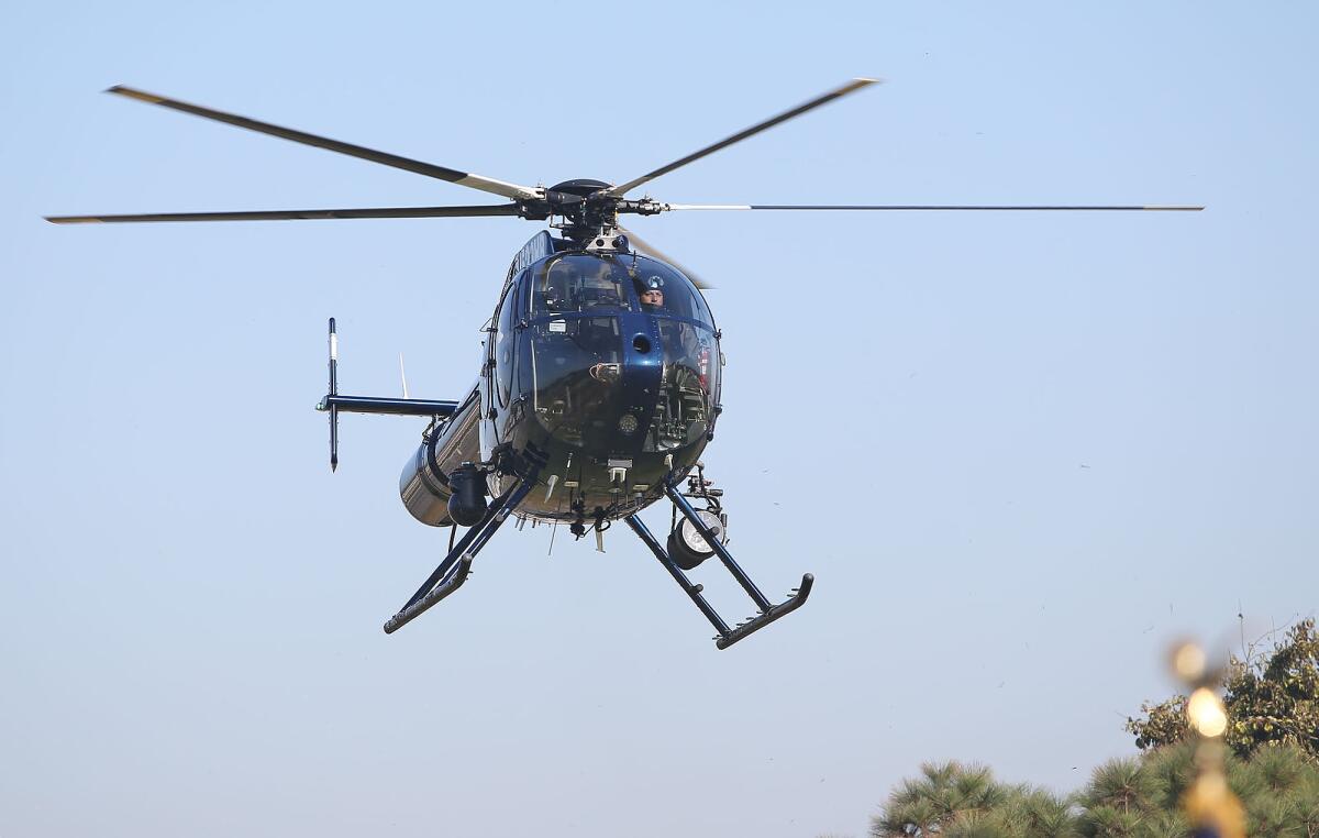 The H.B. police helicopter is spotted in the sky during First Responders Fair and patriotic assembly at an elementary school.