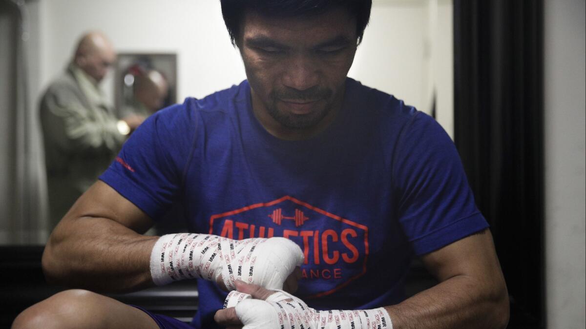 Manny Pacquiao tapes his hands for a workout at the Wild Card boxing club on Jan. 14.