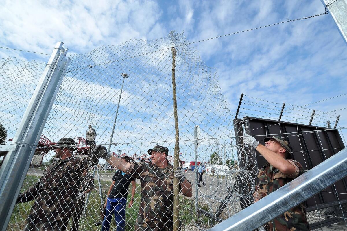 Hungarian soldiers raise fences at the Croatian-Hungarian border crossing between the villages of Baranjsko Petrovo Selo, Croatia, and Beremend, Hungary, on Sept. 22.