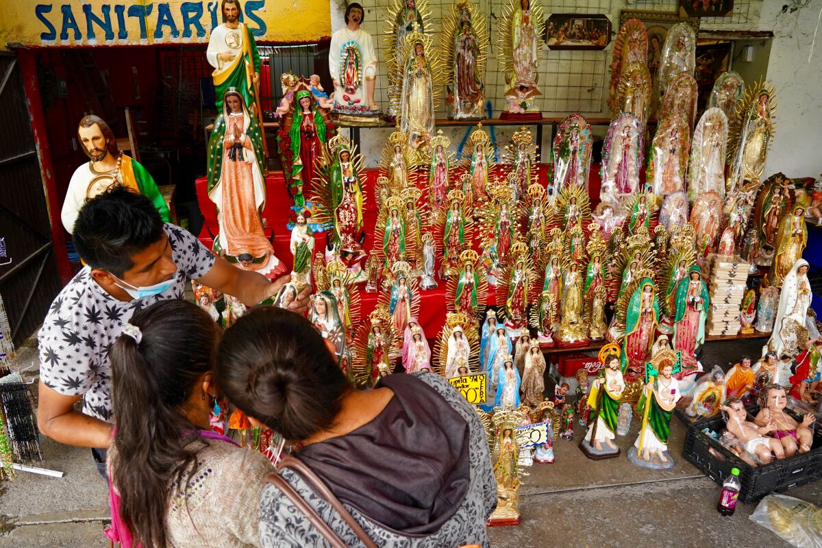 Religious figures fill shelves at one of the few stores open near the basilica.