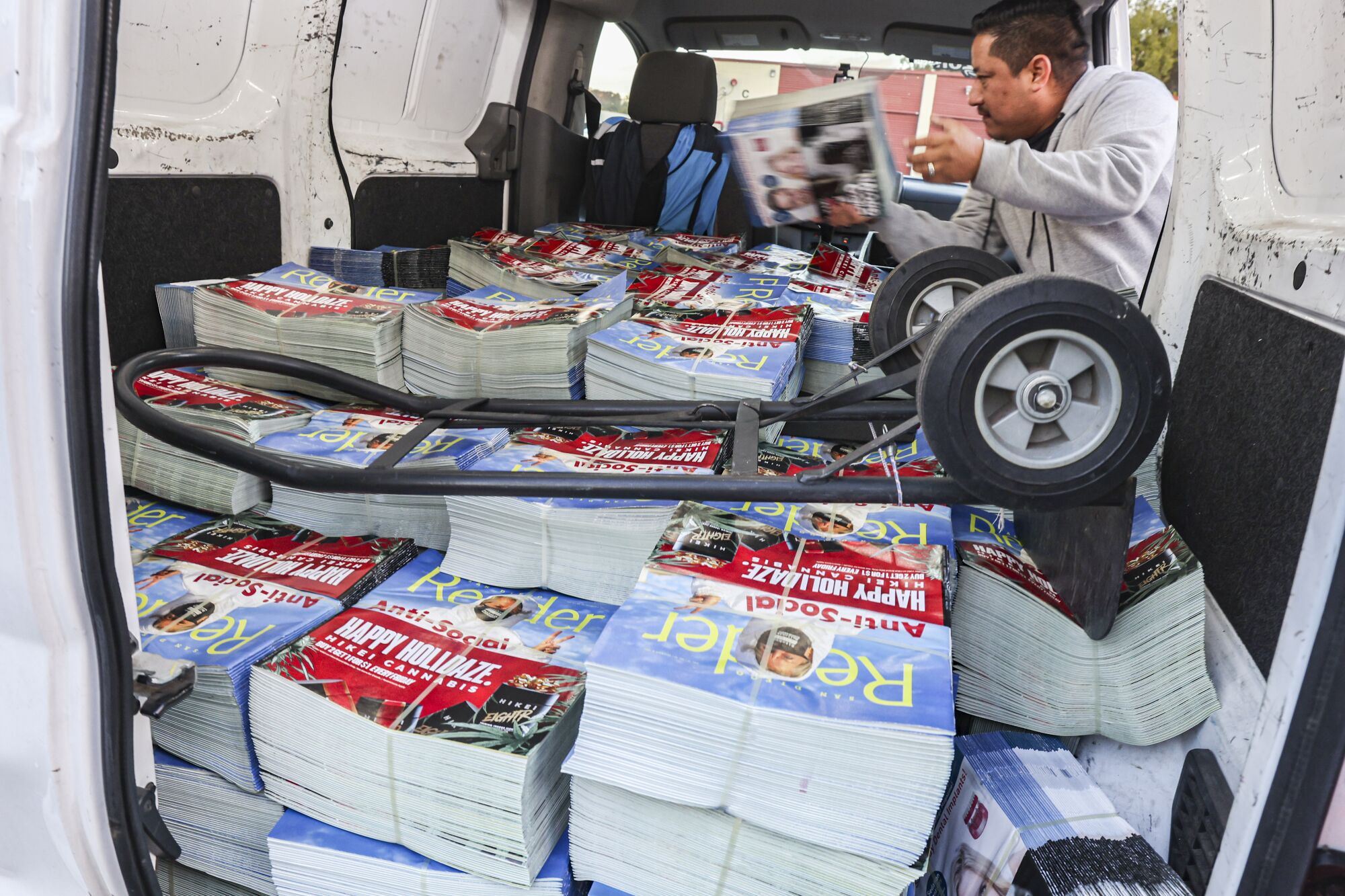 Delivery workers load copies of the San Diego Reader at Price Self Storage.
