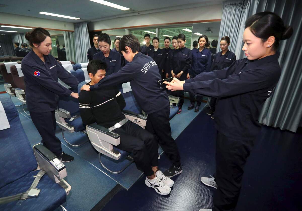 Crew members of Korean Air receive training in handling unruly passengers in a mock cabin in Seoul in 2016.