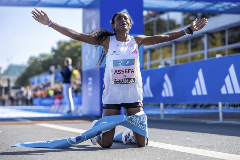 Ethiopia's Tigst Assefa crosses the finish line as the first woman to finish the Berlin Marathon, in Berlin, Sunday, Sept. 24, 2023. (Andreas Gora/dpa via AP)
