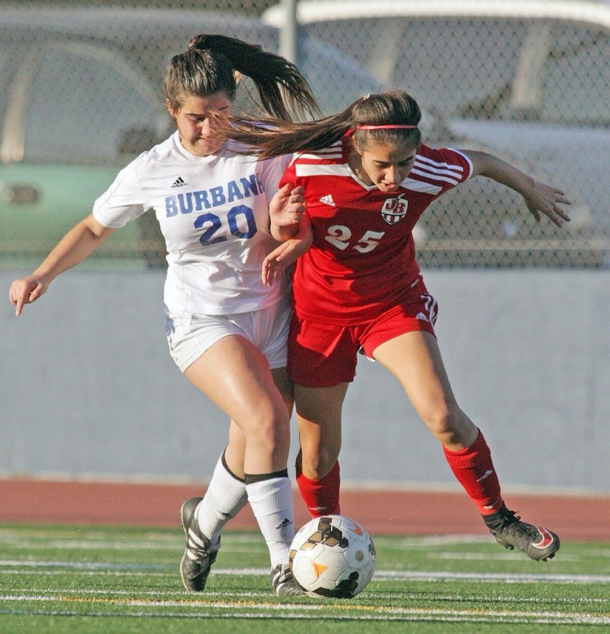 Burbank's Adrianne Sarukhanyan gets challenged hard by Burroughs' Daisy Casteneda for the ball in a Pacific League girls' soccer rivalry game at Burbank on Thursday.