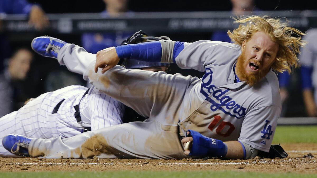 Dodgers shortstop Justin Turner, right, is tagged out at home plate by Colorado Rockies catcher Michael McKenry during the sixth inning of the Dodgers' 10-4 loss Tuesday.
