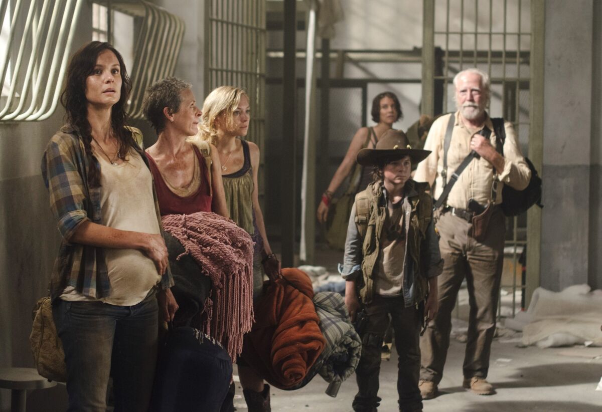 Cast members of "The Walking Dead" in a scene set in a prison.