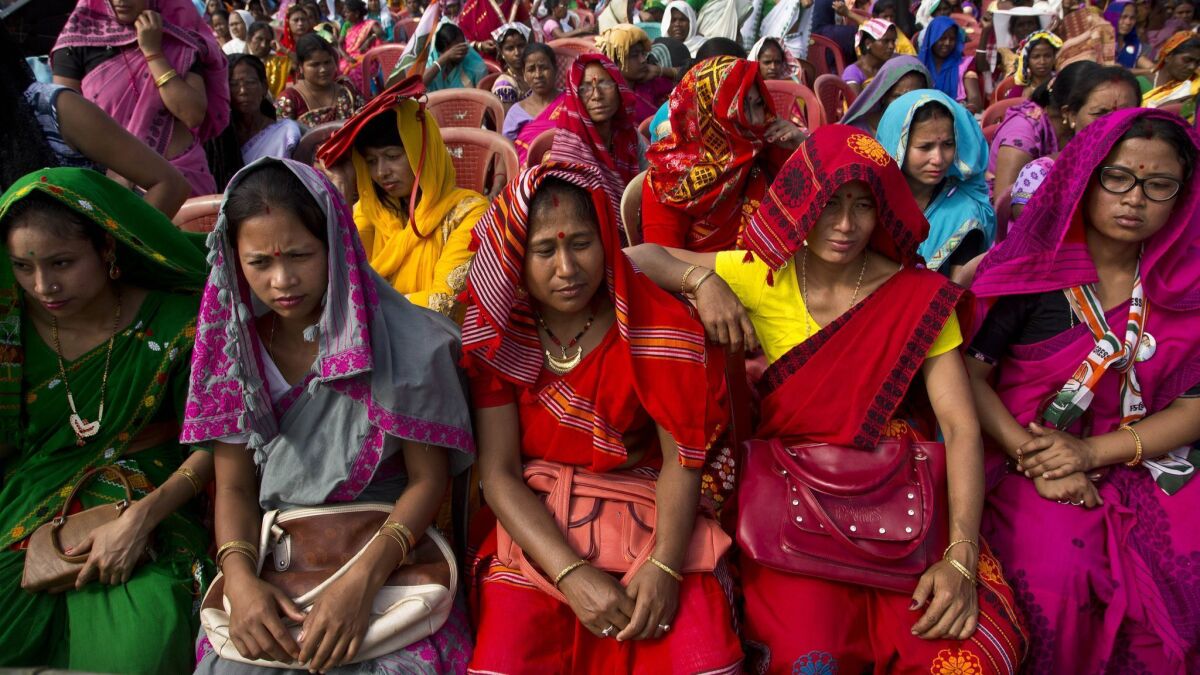 Indian tribal women in traditional attire listen to Congress Party President Rahul Gandhi at a campaign rally in the northeastern state of Assam on April 3, 2019.