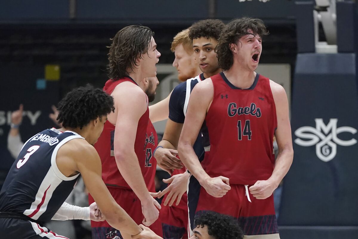 Saint Mary's guard Alex Ducas, back left, celebrates with forward Kyle Bowen (14) during the second half of an NCAA college basketball game against Gonzaga in Moraga, Calif., Saturday, Feb. 26, 2022. (AP Photo/Jeff Chiu)