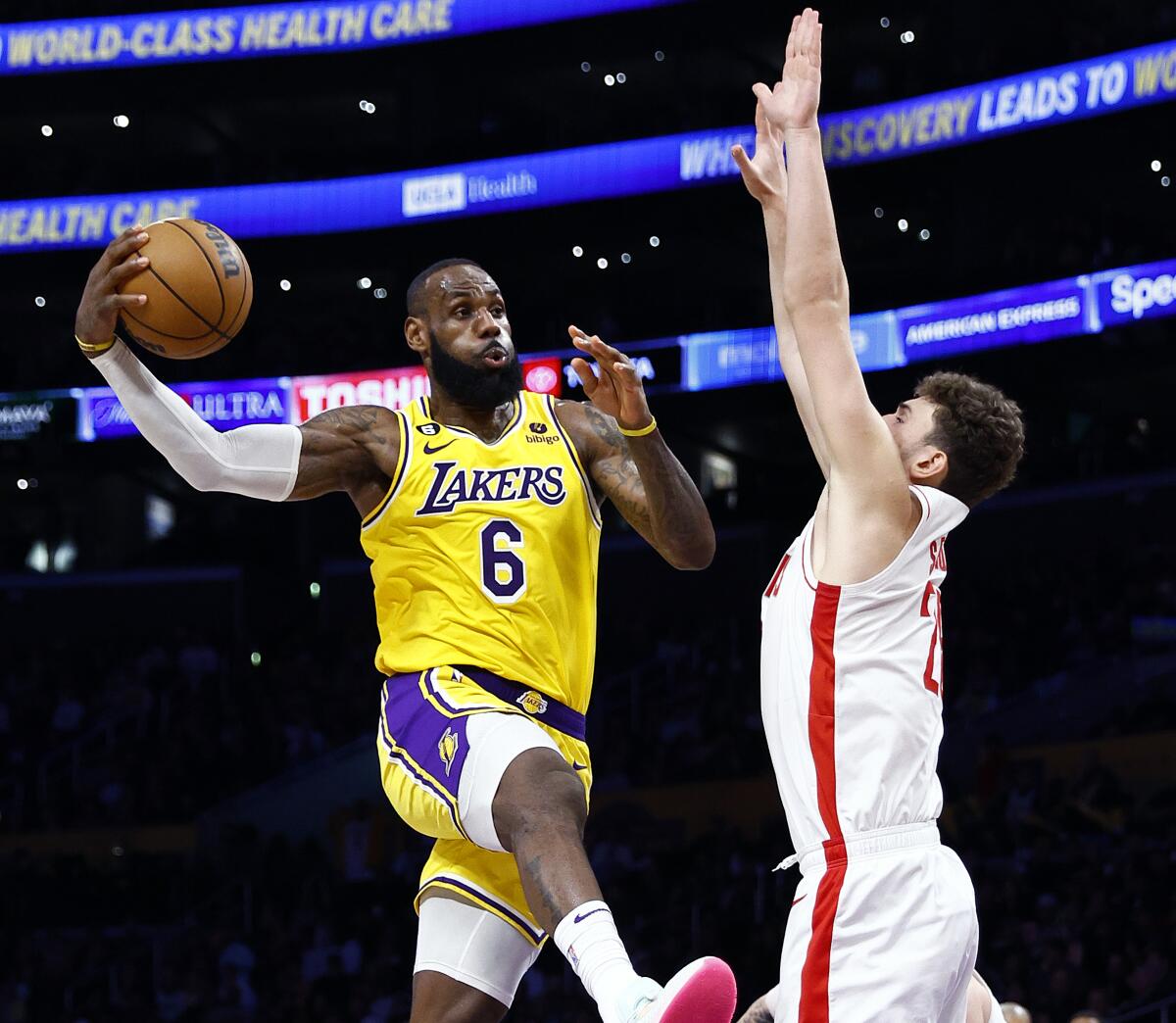 Lakers star LeBron James passes the ball in front of Houston Rockets center Alperen Sengun.