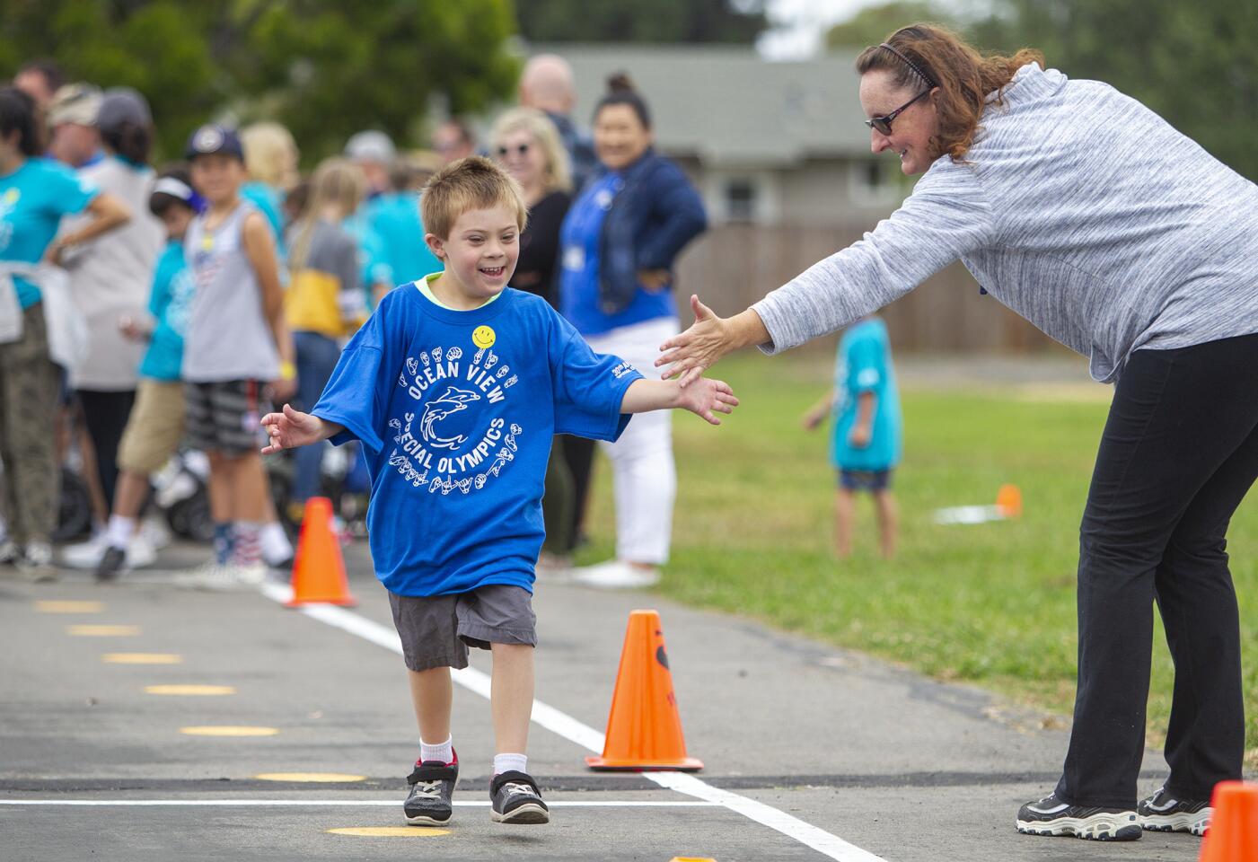 Tiffaney Harper high-fives Gabe Petrella, 7, from Lake View Elementary School during the 30th annual Special Olympics at Village View Elementary School on Friday.