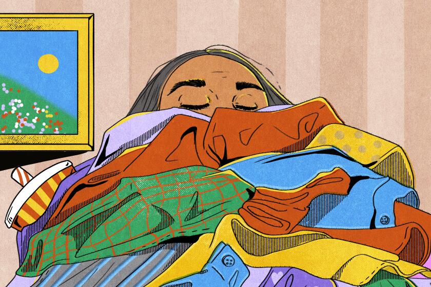 A women holds a pile of clothes 