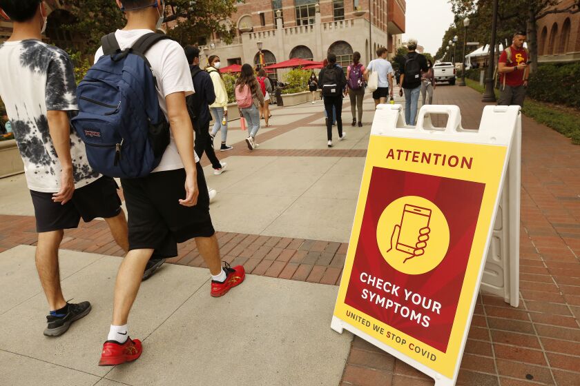 LOS ANGELES, CA - AUGUST 23: Covid warning signage on the campus at USC Monday for the first day of in-person classes. USC and California State University campuses start in-person classes on Monday, serving as a test case for whether vaccine mandates, masking, regular testing and other protocols can minimize spread of the Delta variant even as thousands of students congregate in classes, dorms and social events. USC campus on Monday, Aug. 23, 2021 in Los Angeles, CA. (Al Seib / Los Angeles Times).