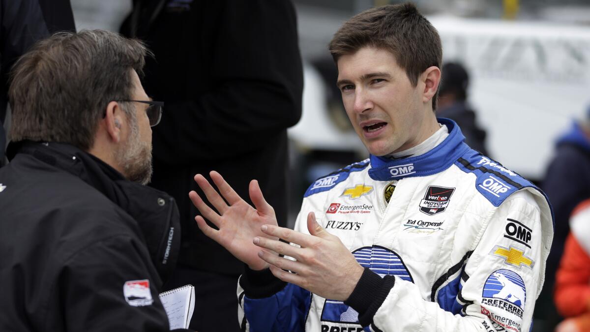 IndyCar Series driver J.R. Hildebrand, right, speaks with a member of his crew after an Indianapolis 500 practice session on May 15. Hildebrand is eager to prove he can win the Indianapolis 500 after his heartbreaking, final-lap loss in 2011.