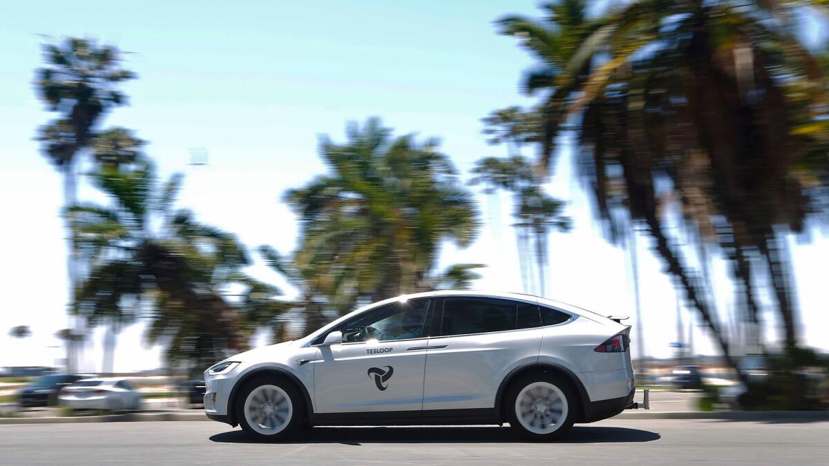A Tesloop car drives near Mission Bay. The ride-sharing service offers trips between cities such as San Diego, Los Angeles, Orange County and Palm Springs. The service uses Teslas with amenities such as wifi, chargers, snacks and drinks.