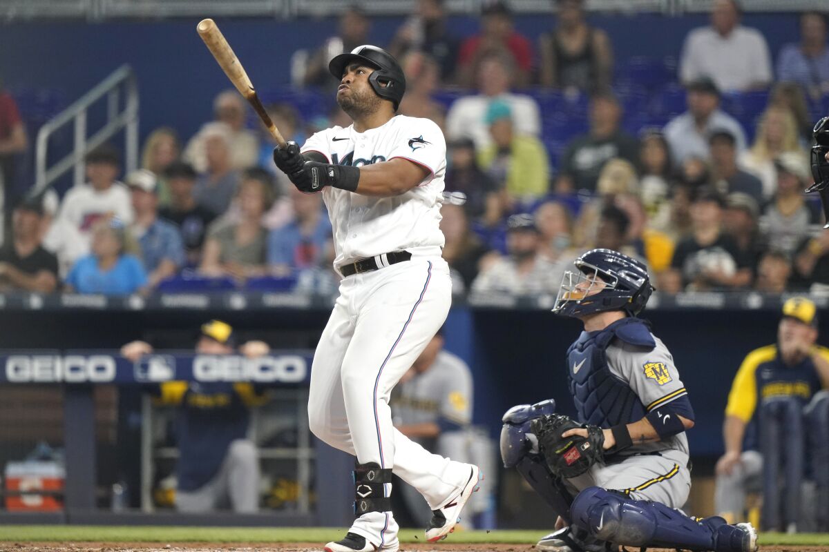 Miami Marlins' Jesus Aguilar, left, watches his solo home run next to Milwaukee Brewers catcher Victor Caratini during the fourth inning of a baseball game Saturday, May 14, 2022, in Miami. (AP Photo/Lynne Sladky)