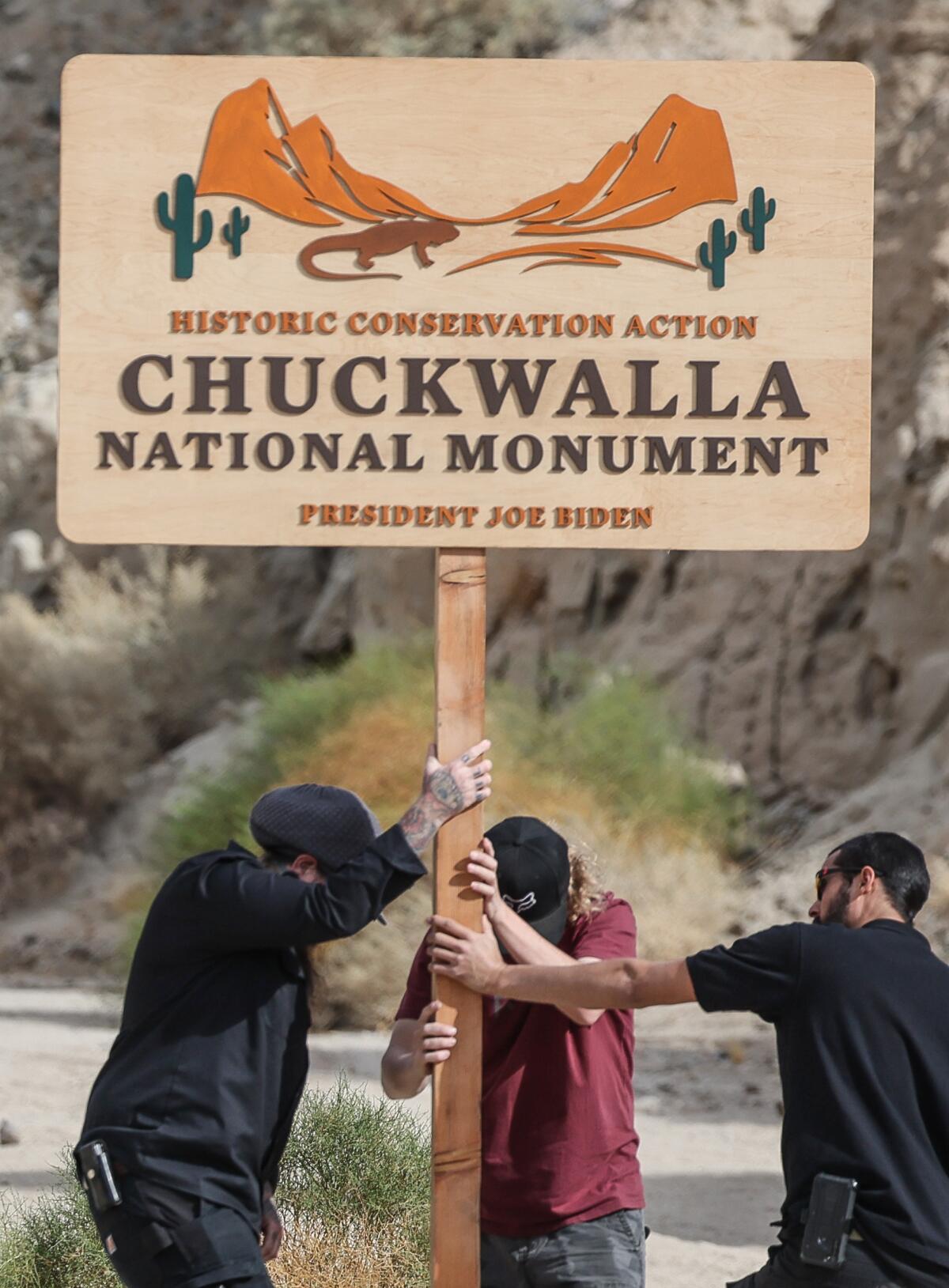 Event workers disassemble a sign