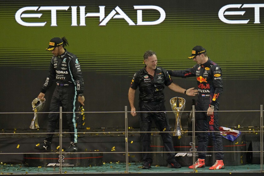 Red Bull team chief Christian Horner, center, celebrates with his driver Max Verstappen of the Netherlands after winning the Formula One Abu Dhabi Grand Prix in Abu Dhabi, United Arab Emirates, Sunday, Dec. 12, 2021. Max Verstappen ripped a record eighth title away from Lewis Hamilton, left, with a pass on the final lap of the Abu Dhabi GP to close one of the most thrilling Formula One seasons in years as the first Dutch world champion. (AP Photo/Hassan Ammar)