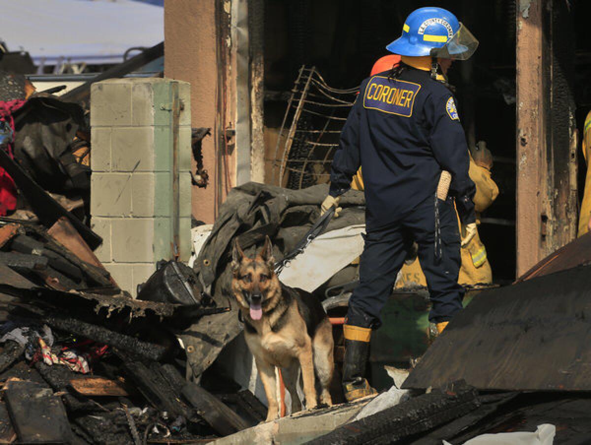 LA County coroner K-9 handler Karina Peck guides her human remains detection canine through the rubble left by a greater alarm fire at 4319 E. Compton Blvd in the East Rancho Dominguez area of Los Angeles.