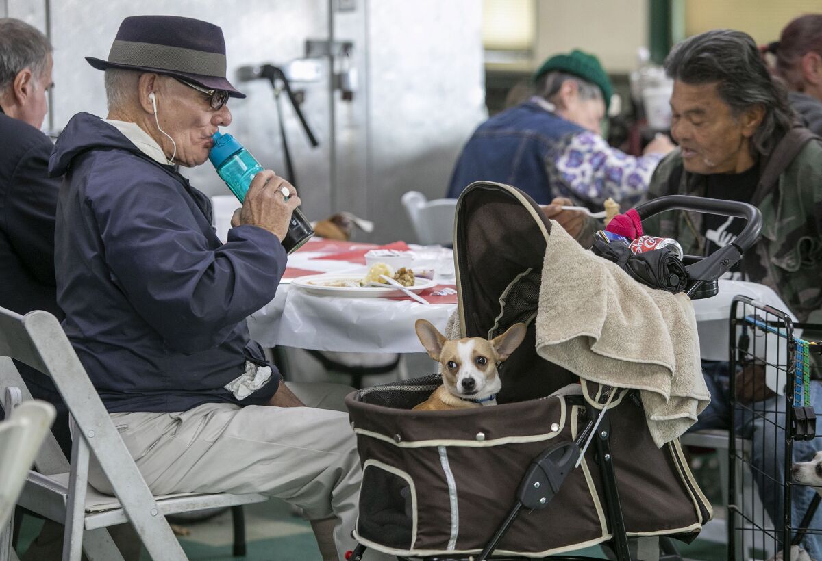 Jack Salmon is accompanied by his dog Loco during a meal for homeless people at Father Joe's Villages in San Diego.