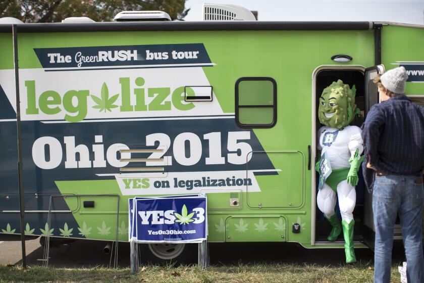 Buddie, the mascot for the pro-marijuana legalization group ResponsibleOhio, steps out of a promotional tour bus at Miami University in Ohio.