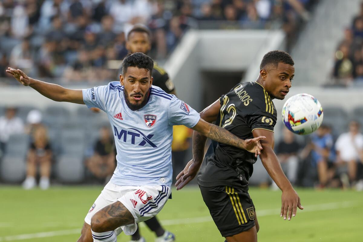 FC Dallas forward Jesus Ferreira, left, and Los Angeles FC defender Diego Palacios (12) vie for the ball during the first half of an MLS soccer match in Los Angeles, Wednesday, June 29, 2022. (AP Photo/Ringo H.W. Chiu)