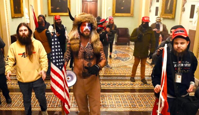 Jake Angeli, in horns and fur, was arrested by the FBI for his role in the Jan. 6 insurrection at the Capitol.