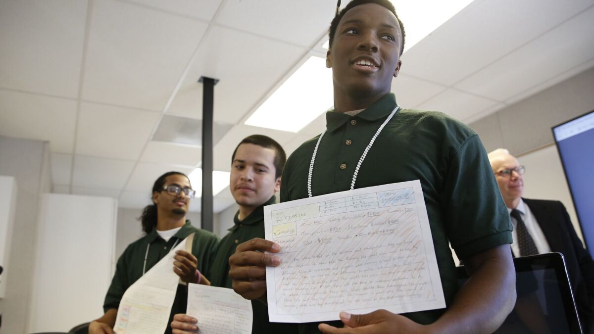 Derrick McDougal, right, a youth inmate at the O.H. Close Youth Correctional Facility, displays a website he helped design, at a computer coding class in Stockton.
