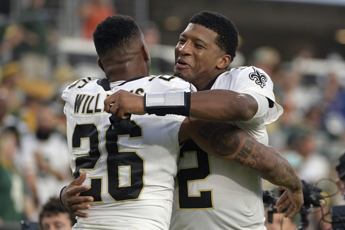 New Orleans Saints cornerback P.J. Williams (26) hugs quarterback Jameis Winston (2) after they defeated the Green Bay Packers in an NFL football game, Sunday, Sept. 12, 2021, in Jacksonville, Fla. (AP Photo/Phelan M. Ebenhack)
